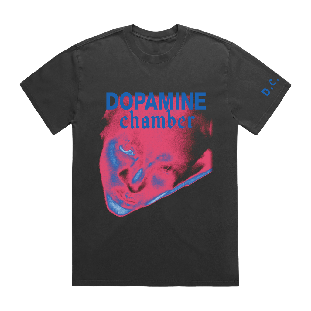 A charcoal gray t-shirt featuring a graphic print of a face in pink and blue
with the text 'DOPAMINE chamber' in blue.