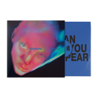 A vinyl record partially pulled from its sleeve, showing the album cover art with a neon close-up portrait and the blue inner sleeve with large black text.