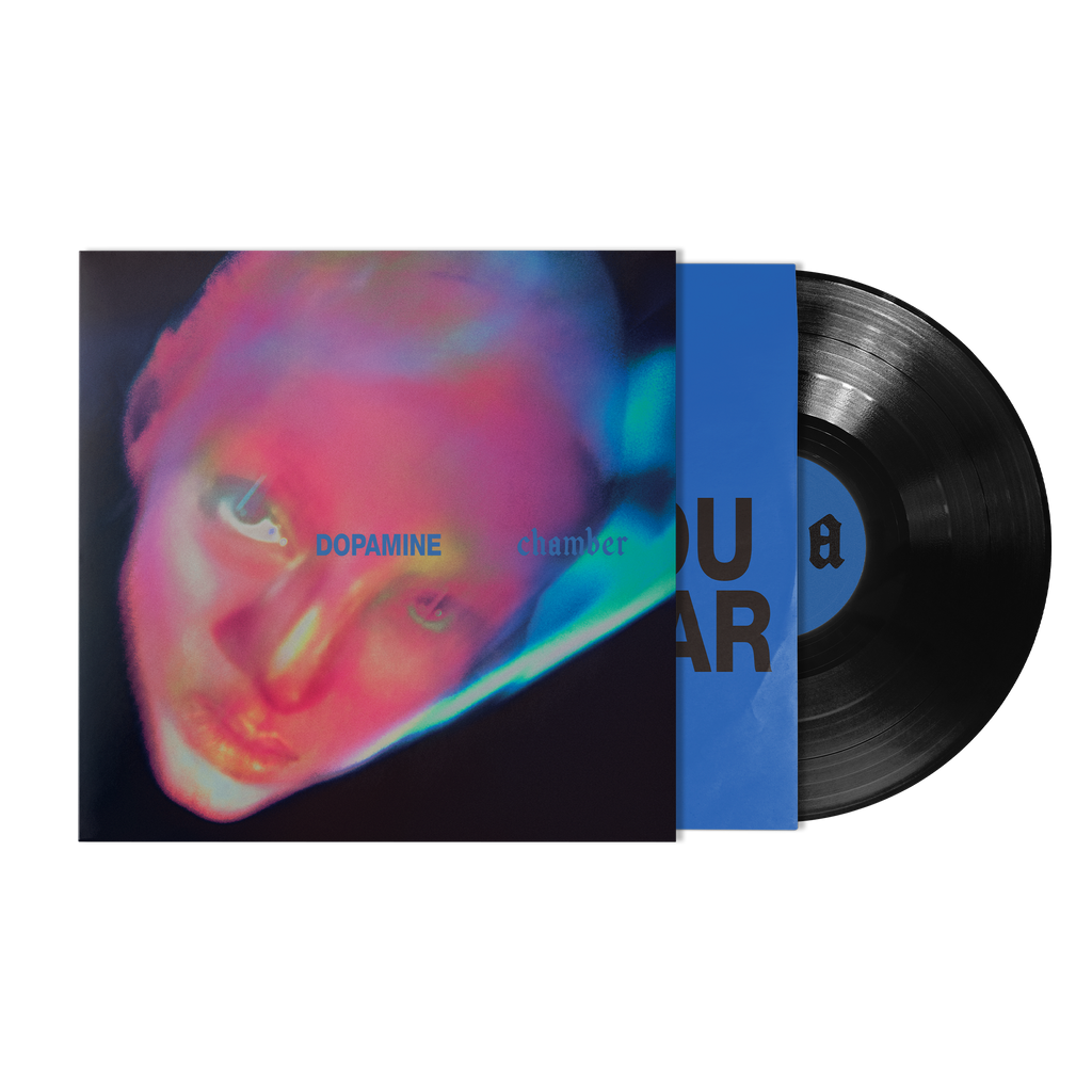 A vinyl record partially pulled from its sleeve, showing a black LP with a blue center label and a colorful album cover.